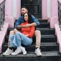 Couple embracing calmly on front steps, representing comfort and closeness in a healthy relationship